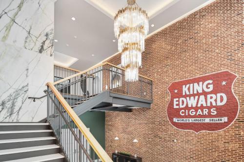 a staircase in a brick building with a chandelier at The Flying Fifty Hotel, a Luxury Boutique Hotel in Cullman