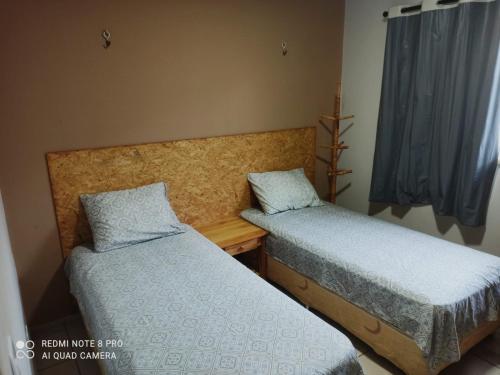 a bedroom with two beds and a window at Casa PHB in Parnaíba
