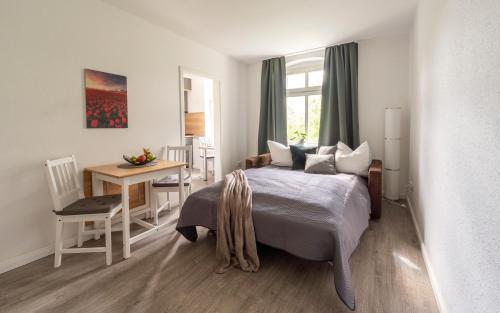 a bedroom with a bed and a table and a desk at Apartment an der Uni Klinik in Magdeburg