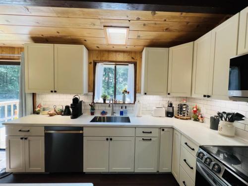 a kitchen with white cabinets and a sink at Perch - Ellie's Secret Cabin in Coupeville