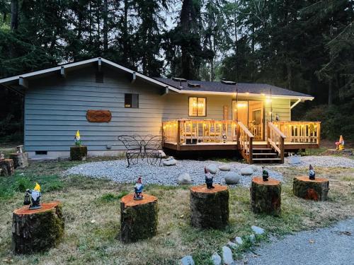a house with some figurines on logs in front of it at Perch - Ellie's Secret Cabin in Coupeville