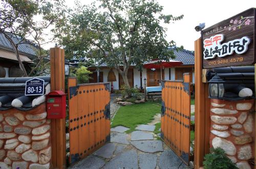 a fence in front of a house with a sign at Hanok Madang in Jeonju