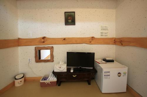 a room with a small refrigerator and a television at Hanok Madang in Jeonju