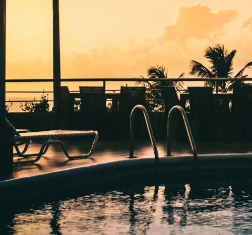 una piscina con silla y agua en Hotel Eduards Suite en Macuto
