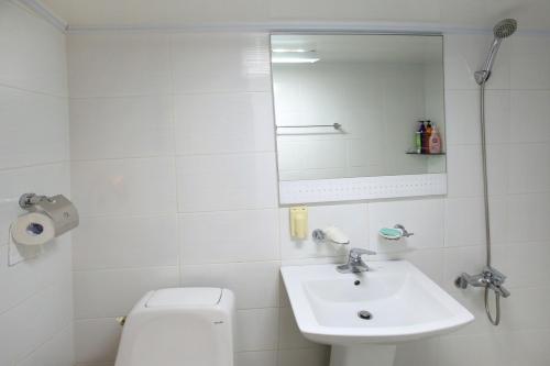 a bathroom with a sink and a toilet and a mirror at Hanok Madang in Jeonju