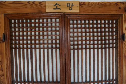 a wooden door with a sign on top of it at Hanok Madang in Jeonju