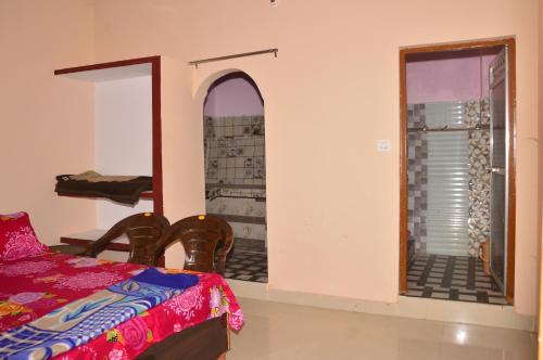 a bedroom with a bed and a door to a balcony at GAYATRI HOMESTAY in Rudraprayāg