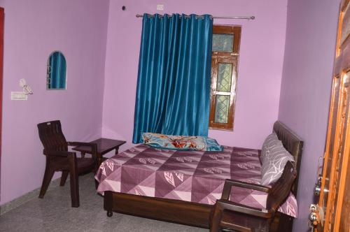 a bedroom with a bed and two chairs and a window at GAYATRI HOMESTAY in Rudraprayāg