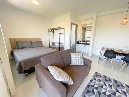 a living room with a couch and a bed at Condomínio Residencial Unique Residence - São José do Rio Preto in Sao Jose do Rio Preto