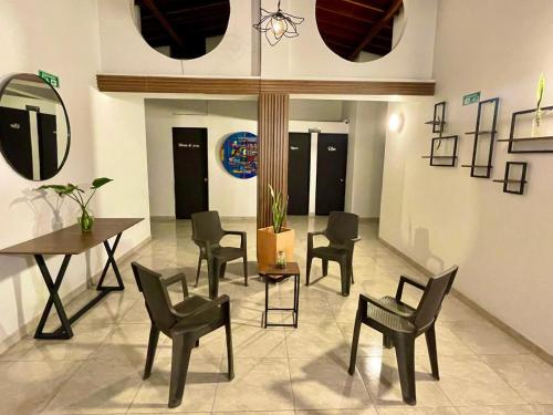 uma sala de estar com cadeiras, uma mesa e um espelho em Hotel Turístico El Cedral em Socorro