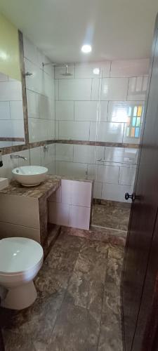 a bathroom with a toilet and a sink at Hotel Campestre Los Mangos in Quimbaya