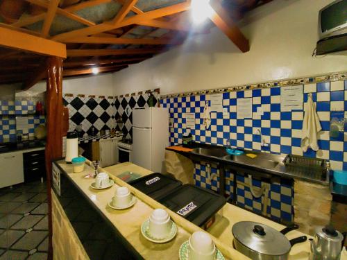 a kitchen with blue and white tiles on the wall at Chapadão Hostel in Lençóis
