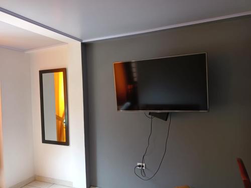 una TV a schermo piatto appesa a un muro di Casa Hamburgo a Pereira