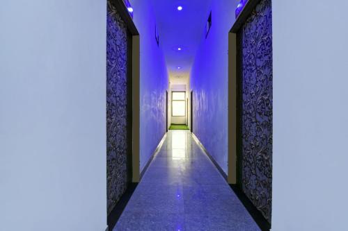 einen Flur mit lila Wänden und einer Tür in der Unterkunft OYO Hotel Ishwar in Jaipur