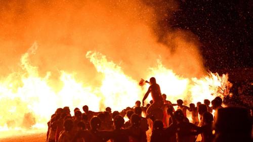 a crowd of people standing in front of a fire at Vessel Inn Shigamoriyama Station in Moriyama