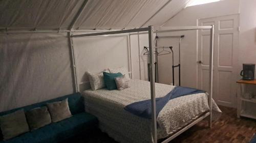 a bedroom with a bed with a canopy at Garza del Sol Glamping Río Celeste Buganvilia in San Rafael