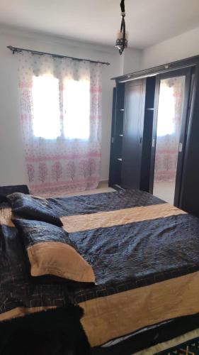 Un dormitorio con una cama grande y una ventana en سيدي عثمان الابيض en Rabat