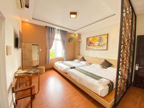 1 dormitorio con 1 cama grande con marco de madera en Hong My Hotel, en Kon Tum (2)