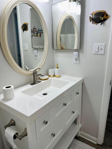 a white bathroom with a sink and a mirror at Condo at Happy Hour Tybee in Tybee Island