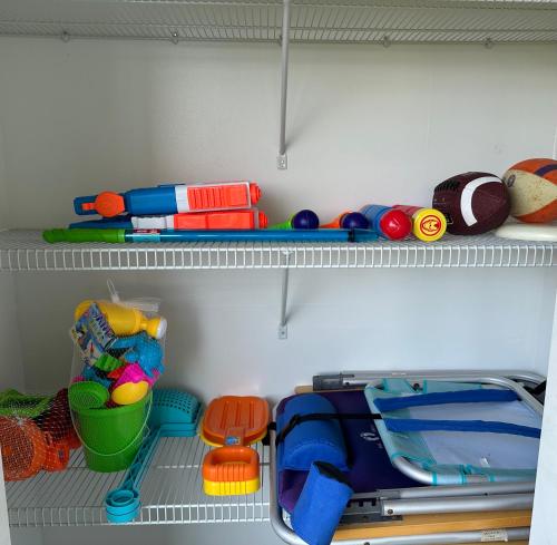 a closet filled with lots of toys on shelves at Condo at Happy Hour Tybee in Tybee Island