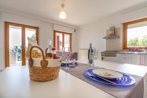 a kitchen with a table with a basket of wine glasses at AbruzzodAmare Amazing Apartments with Romantic Sea View in Francavilla al Mare