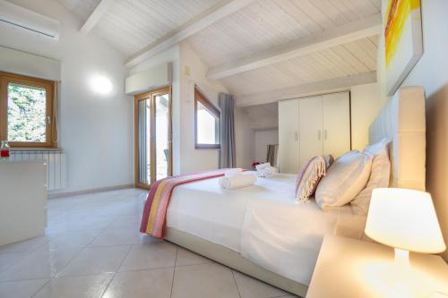 a bedroom with a large white bed and a lamp at AbruzzodAmare Amazing Apartments with Romantic Sea View in Francavilla al Mare