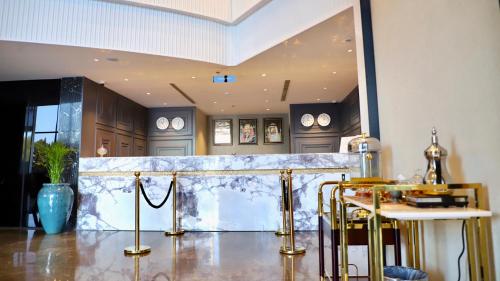 a lobby with a marble counter with clocks on the wall at Five Seasons Hotel in Tabuk
