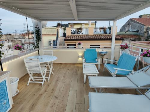 a balcony with blue chairs and tables on a building at The Sorabellas in Gaeta