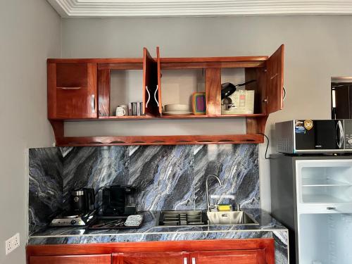 - une cuisine avec des placards en bois et un comptoir dans l'établissement Renda Residence, à Deabenekrom