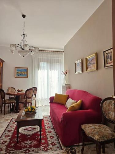 a living room with a red couch and a table at La Casa di Nonna Gina in Alba