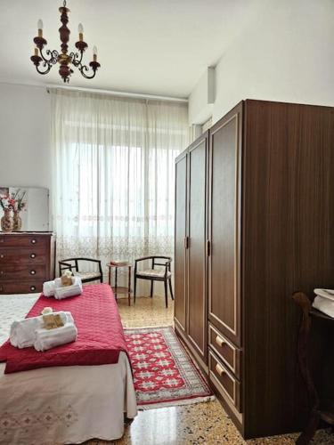 a bedroom with a bed and a large wooden cabinet at La Casa di Nonna Gina in Alba