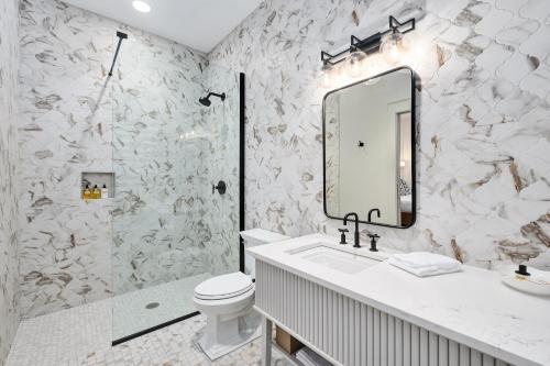 a bathroom with a toilet and a sink and a mirror at The Flying Fifty Hotel, a Luxury Boutique Hotel in Cullman