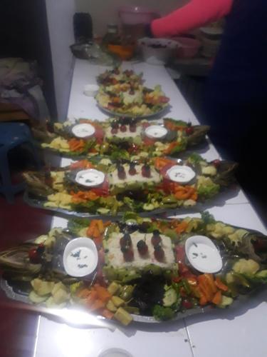 eine Reihe von Tellern mit Lebensmitteln auf einem Tisch in der Unterkunft maison d hote timentour in Tiguissas