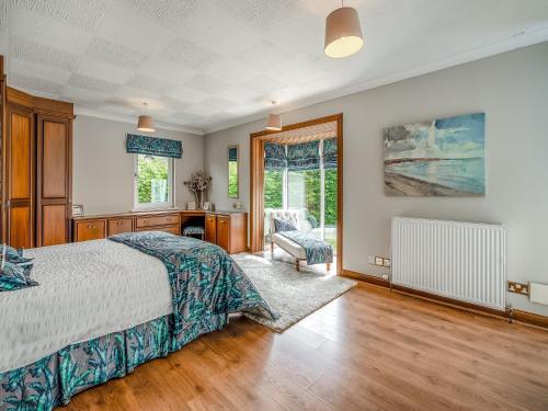 een slaapkamer met een bed, een bureau en een raam bij Tigh Na Beannaich in Powmill