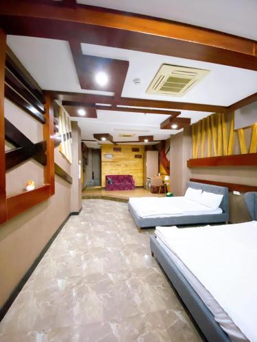 a large room with three beds in it at Hang Chau Hotel in Can Tho