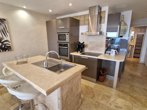 une cuisine avec un évier et un plan de travail dans l'établissement Appartement climatisé avec piscine, terrasse vue mer et parking à Sainte-Maxime - FR-1-780-38, à Sainte-Maxime