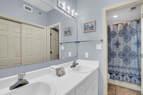 La salle de bains blanche est pourvue d'un lavabo et d'un miroir. dans l'établissement Tidewater 702, à Orange Beach