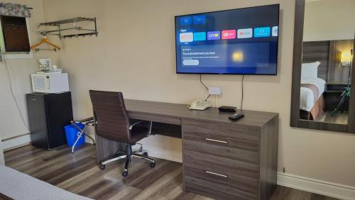 an office with a desk with a television on a wall at Maple Leaf Inn & Suites in Kincardine