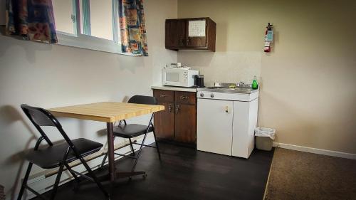a small kitchen with a table and a microwave at Maple Leaf Inn & Suites in Kincardine