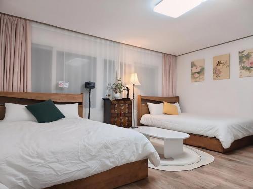 a hotel room with two beds and a table at JB Stay#Hongdae & Sinchon 10min#Double Room in Seoul