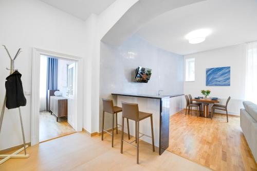 a kitchen and living room with a table and chairs at Bishop Apartments in Brno