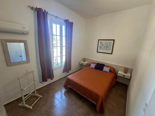 een slaapkamer met een bed en een raam bij Incantare ApartHotel in Piriápolis