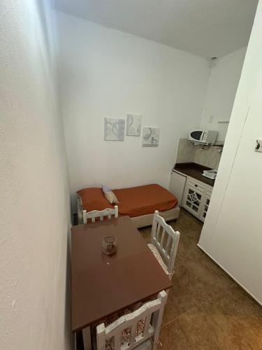 een kleine kamer met een tafel en een bed bij Incantare ApartHotel in Piriápolis