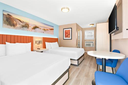 Habitación de hotel con 2 camas y mesa en Mango Motel, en Wildwood