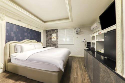 Nobless Motel في Sin-ni: غرفة نوم بسرير كبير وتلفزيون