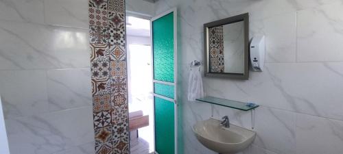 Baño blanco con lavabo y espejo en Cabaña la Gloria, en San Onofre