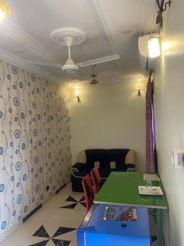 ein Wohnzimmer mit einem grünen Tisch und einem Sofa in der Unterkunft RÉSIDENCE ACHIKA INELIA in Bobo-Dioulasso