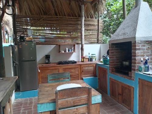 a kitchen with a table and a refrigerator at El Puente in El Paredón Buena Vista