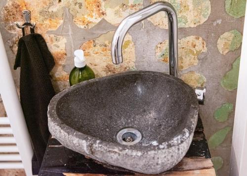 lavabo de piedra con grifo en el baño en Boutique Altbau Apartment en Berlín