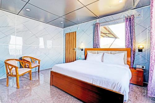 sypialnia z dużym łóżkiem i krzesłem w obiekcie OYO Hotel Neilkanth w mieście Dhanaulti